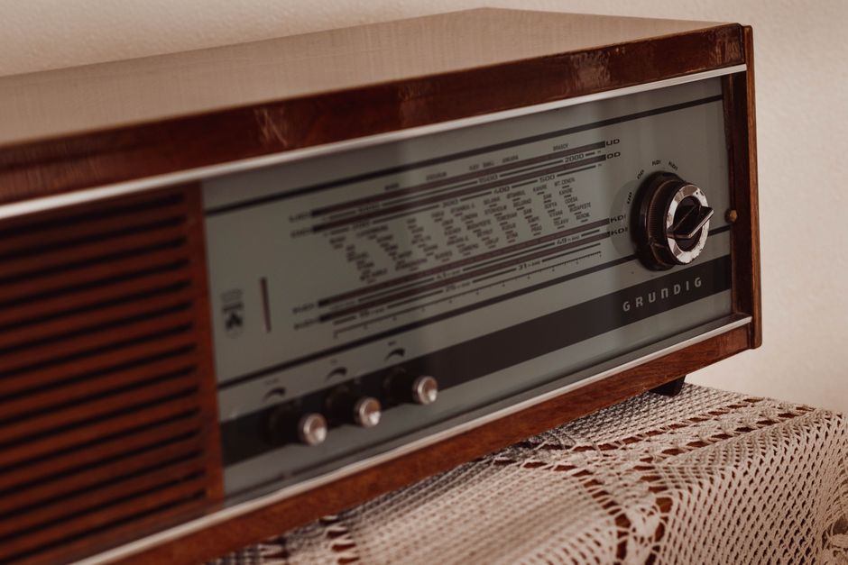 Control panel of vintage radio receiver placed on tablecloth on wooden table in old apartment